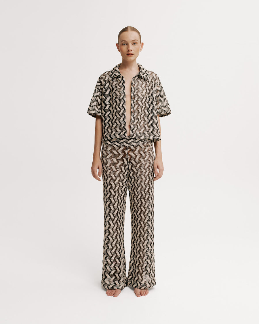 Person wearing a patterned outfit on a white background